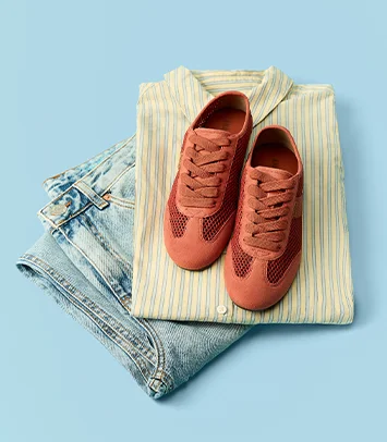 Tênis de malha terracota sobre camisa listrada e jeans